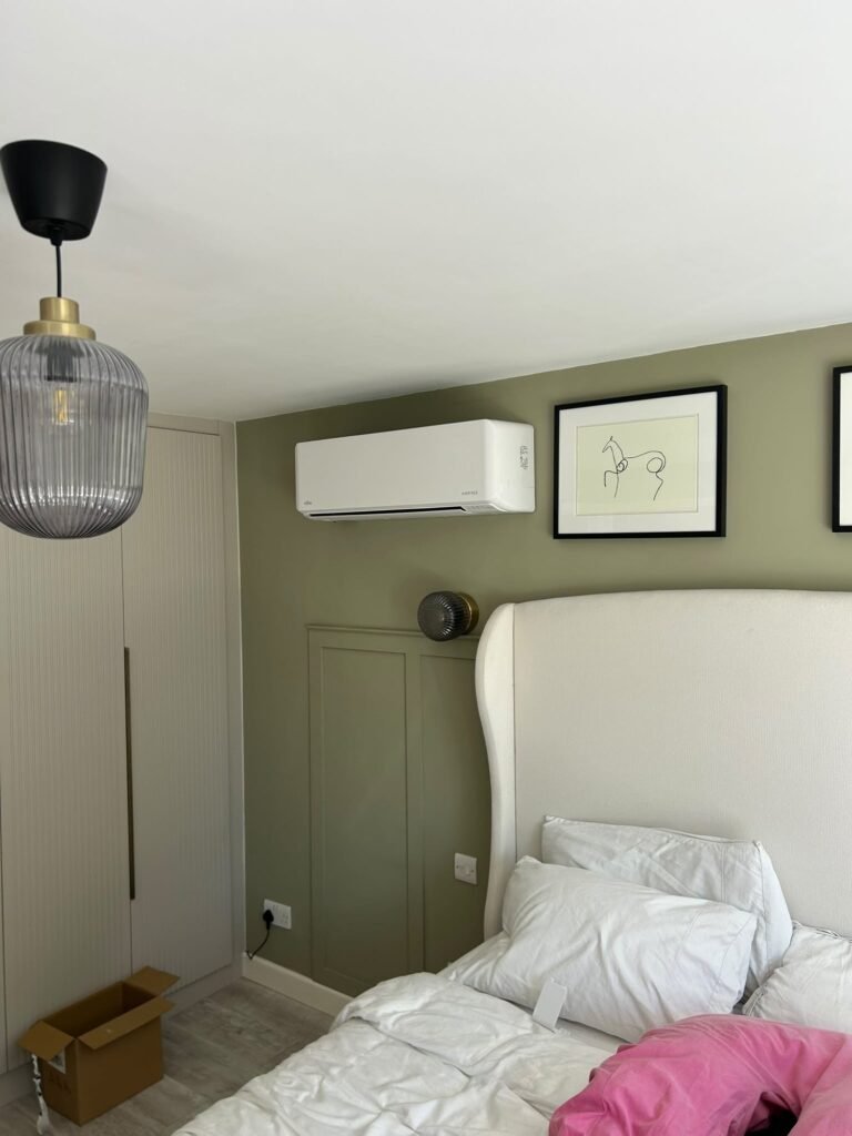 Air conditioning above the bed in a green bedroom