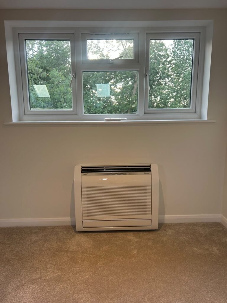 Floor-standing air conditioning unit beneath a window