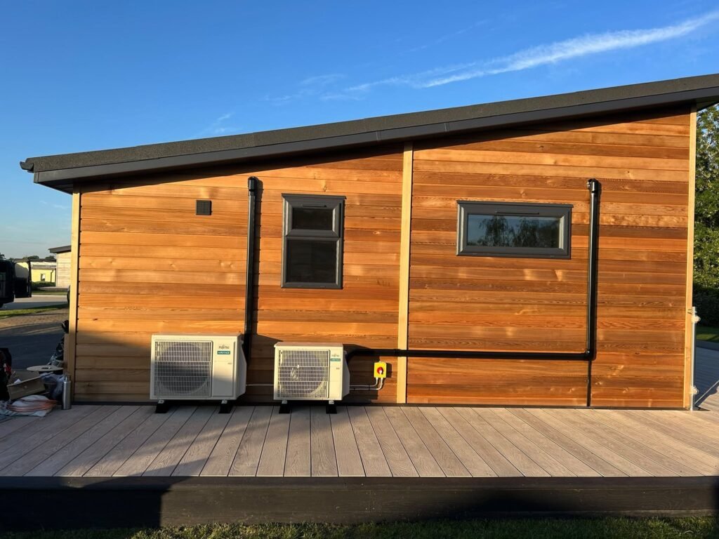 Two outdoor units neatly installed beside a cedar-clad garden room