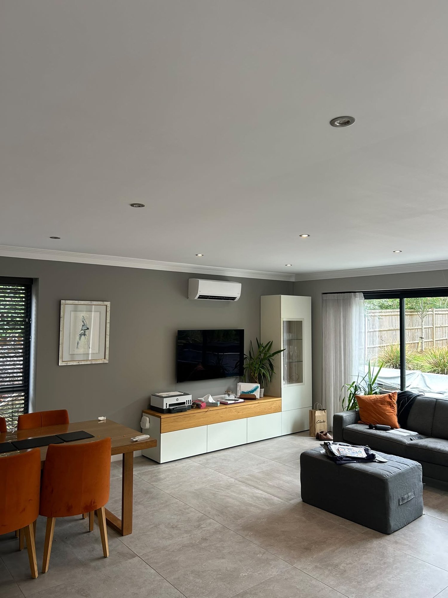 Wall-mounted air conditioning above a living room television wall