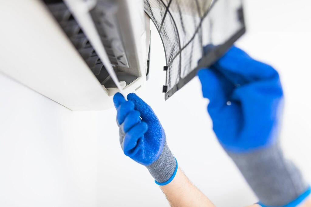 Engineer removing the filter from an indoor unit for cleaning
