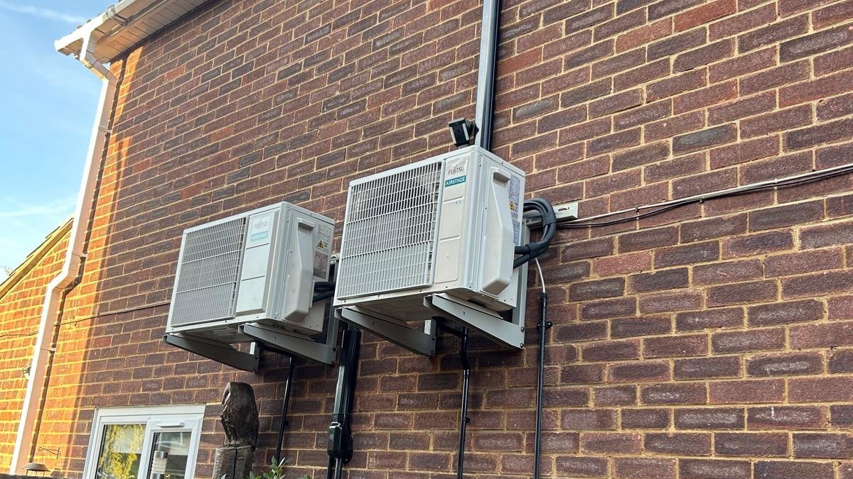 A row of outdoor units installed neatly against a brick wall